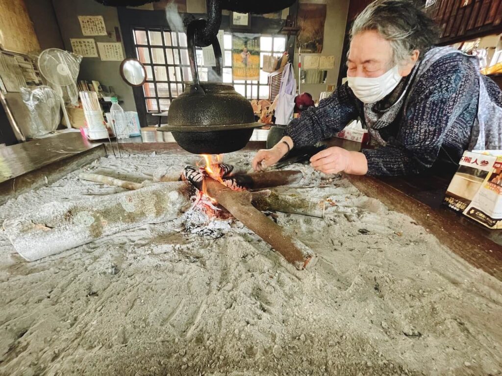 曽木の滝そば庵_囲炉裏に火をくべる女将